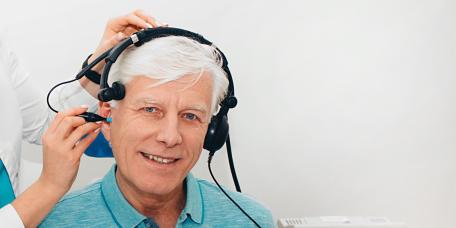 Ärztin untersucht Ohr des Patienten