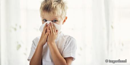 kleiner Junge putzt sich die Nase